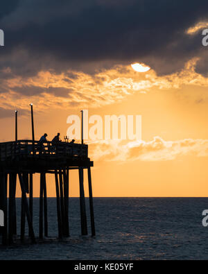 Angler ihr Glück versuchen, kurz nach Sonnenaufgang, im Avon Fishing Pier auf der Insel Hatteras, North Carolina. Stockfoto