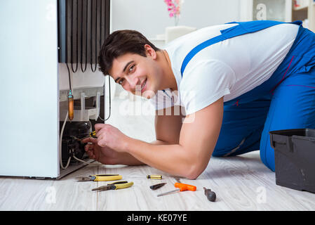 Handwerker Auftragnehmer Instandsetzung Kühlschrank im DIY-Konzept Stockfoto