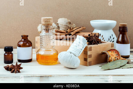 Flasche ätherische Öl für Ayurveda Massage mit Zimtstange, Sternanis, Lorbeerblätter Ingwerwurzel und herbal Ball komprimieren Mit selektiven Fokus auf Stockfoto