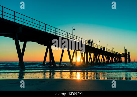 Glenelg Beach Sonnenuntergang mit Menschen auf dem Bootssteg in Adelaide, South Australia Stockfoto