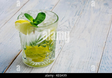 Alkohol mojito cocktil Bar long Drink frische tropische Trinken nach oben Ansichtskopie Raum highball Glas, mit Rum, Minze, Limettensaft, Mineralwasser und Eis auf weißem Beton. Stockfoto