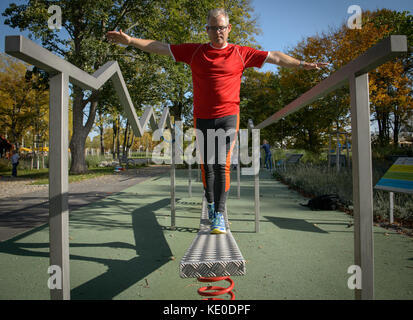 Bad Schönborn, Deutschland. Oktober 2017. Klaus Heinzmann, Teilnehmer einer Langzeitstudie zum Gesundheitsvergleich von sportlich aktiven und nicht sportlich aktiven Menschen, praktiziert in einem Aktivpark in Bad Schönborn, 16. Oktober 2017. Die Studie der Gemeinde Schönborn und des Karlsruher Instituts für Technologie (KIT) läuft seit 25 Jahren. Das Ergebnis: Sportlich aktive Menschen mittleren Alters verfügen über bessere motorische Fähigkeiten, die einen Unterschied zwischen 10 Jahren und Menschen machen, die nicht sportlich aktiv sind. Quelle: Sina Schuldt/dpa/Alamy Live News Stockfoto