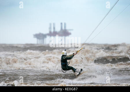 Kitesurfen bei Windböen ; Hurricane Ophelia (Okt 2017) Windböen an der Nordwestküste Englands, wenn Kitesurfer die windigen Bedingungen optimal nutzen, um die Wellen am Ainsdale Beach, nahe Southport in Merseyside, UK, zu fangen Stockfoto