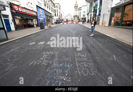 Brighton, Großbritannien. Oktober 2017. Die Öffentlichkeit hat eine Brighton Street während der Reparatur in eine leere Leinwand für Kunstwerke und Graffiti verwandelt . In der North Street im Stadtzentrum werden wesentliche Verbesserungen von Southern Water durchgeführt, und während es leer ist, haben die Öffentlichkeit begonnen, Kreidebotschaften und Kunstwerke auf dem neu gelegten Asphalt zu hinterlassen. Credit: Simon Dack/Alamy Live News Stockfoto