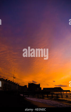 Aberystwyth Wales UK, Dienstag, 17. Oktober 2017 UK Wetter: Ein schöner und dramatischer roter Himmel bei Sonnenuntergang über dem Royal Pier am Meer in Aberystwyth an der Cardigan Bay Küste von West wales Foto: Keith Morris/Alamy Live News Stockfoto