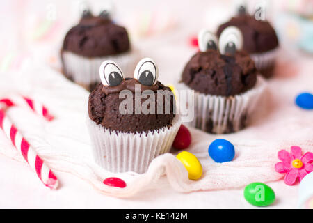 Chocolate Muffins mit essbaren Augen und bunte Bonbons Dessert Stockfoto