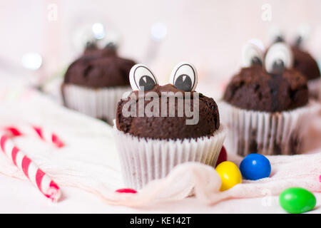 Chocolate Muffins mit essbaren Augen und bunte Bonbons Dessert Stockfoto