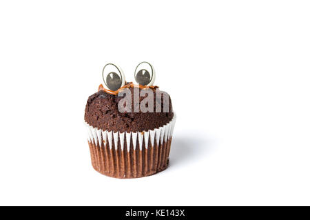 Chocolate Muffin mit essbaren Augen in Papier Halter auf Weiß Stockfoto