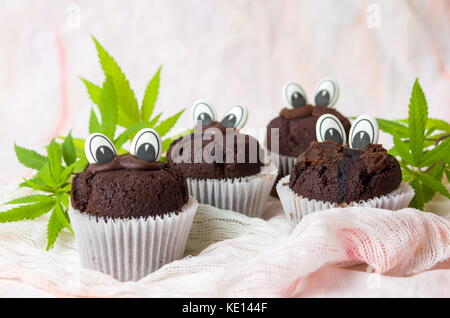 Chocolate Muffins mit Marihuana und genießbare Augen in Papier Halter Stockfoto