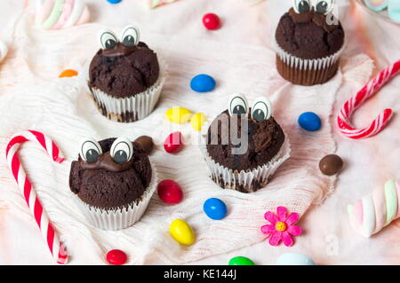 Chocolate Muffins mit essbaren Augen und bunte Bonbons Dessert Stockfoto