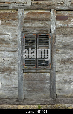 Alte Holz- Fenster mit Holzjalousien auf einem verlassenen Holzhaus Stockfoto