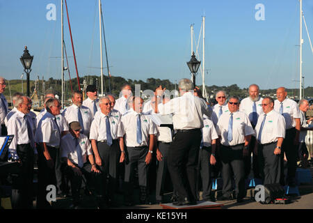 Ein Männerchor an einem Sommerabend in den Hafen von Padstow, North Cornwall. Stockfoto