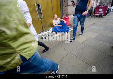 London, England, UK. Menschen zu Fuß vorbei an einem Obdachlosen auf der Straße Stockfoto