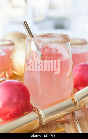 Rosa Sekt Cocktail und Festliche Weihnachtsdekorationen Stockfoto