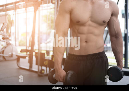 Junger Mann Aufzug Hantel in der Turnhalle. Bodybuilder männlich Sie im Fitnesscenter arbeiten. sport Kerl, Übungen im Health Club. Stockfoto