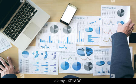 Geschäftsmann Hände arbeiten mit Computer und Smartphone mit Business graph auf dem Schreibtisch als Konzept. Stockfoto