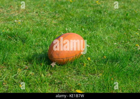 Kiew, Ukraine - 29. April 2017: American Football Ball liegen entlang auf Gras im sonnigen Tag Stockfoto