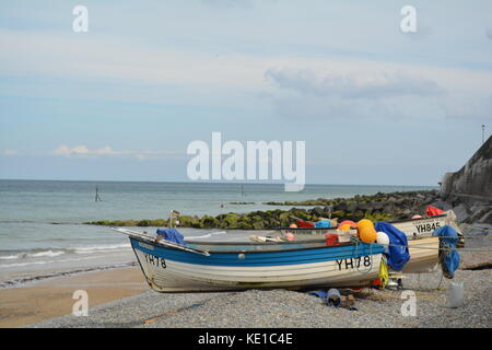 Kleine Fischerboote auf dem Kiesstrand in Sheringham Stockfoto