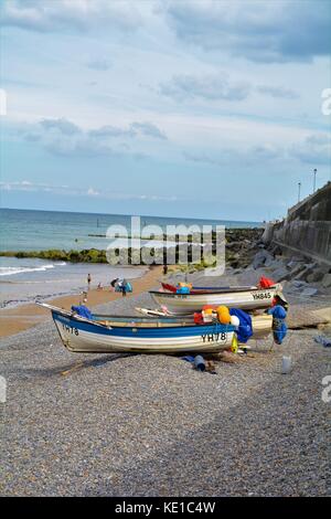 Kleine Fischerboote auf dem Kiesstrand in Sheringham Stockfoto