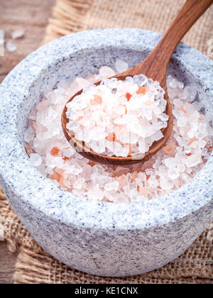 Himalaya Pink salt in Mörtel auf Hanf sack Hintergrund. Himalaya-salz häufig in Kochen und für Badewanne Produkte wie Badesalz verwendet Stockfoto
