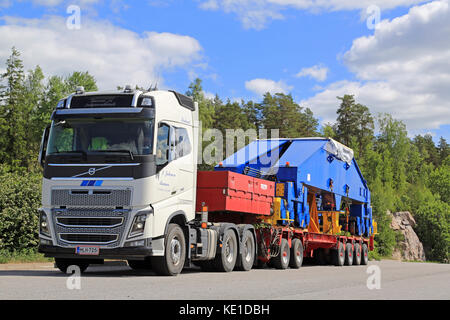 Paimio, Finnland - Juni 4, 2016: weiße Volvo FH 16 750 Transporte Shipyard-krane Drehgestell am Anhänger. die 48 Tonnen schwere Last um 24 Räder unterstützt wird. Stockfoto