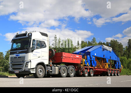 Paimio, Finnland - Juni 4, 2016: weiße Volvo FH 16 750 Transporte Shipyard-krane Drehgestell am Anhänger. die 48 Tonnen schwere Last um 24 Räder unterstützt wird. Stockfoto