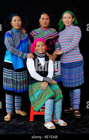 Sünde Cheng, Vietnam, 26. Oktober 2016: Frauen vor einem schwarzen Blatt. HMong Frauen im Norden Vietnams tragen ihre beste traditionelle Kleidung beim Gehen zu Stockfoto