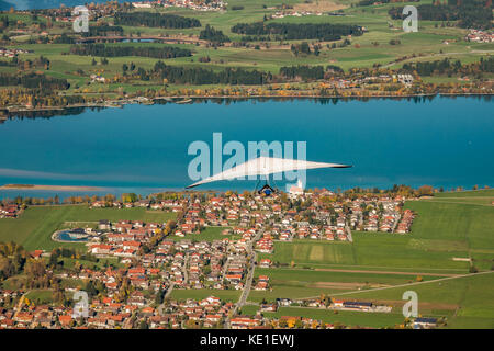 Hängegleiter fliegt über die bayrische Fuss und den Forggensee Stockfoto