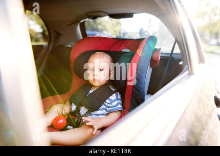 Süße kleine Baby boy in den Autositz sitzen im Auto, raus suchen. Stockfoto