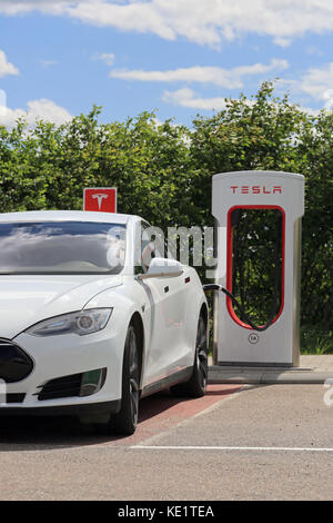 PAIMIO, FINNLAND - Juni 4, 2016: Weiße Tesla Model S Elektroauto wird bei Tesla Kompressor Station aufgeladen. Aufladen der Batterie von 10 bis 80 Pe Stockfoto
