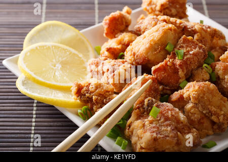 Japanische Gerichte: Gebratenes Huhn mit Zitrone karaage Close-up auf einem Teller auf den Tisch. Horizontale Stockfoto