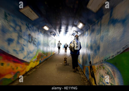 Surreale Ansicht von Fußgängern verschwommene Bewegung im Lackierten graffiti Unterführung Stockfoto