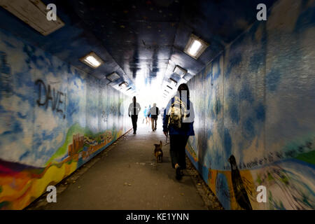 Surreale Ansicht von Fußgängern verschwommene Bewegung im Lackierten graffiti Unterführung Stockfoto