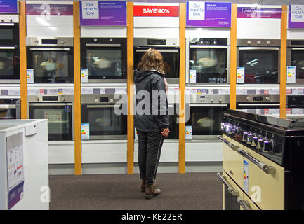 Frau an Öfen suchen auf Anzeige in einer currys elektrische Store, UK. Stockfoto