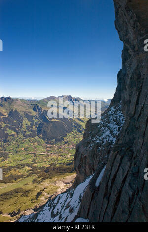 Der beliebte Ferienort Grindelwald in seinem Hochtal in der Ferne von der Nordwand des Eiger, Berner Oberland, Schweiz gesehen Stockfoto