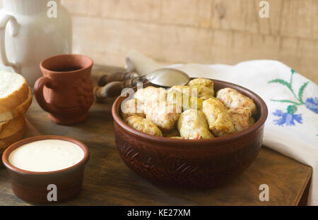 Kohlrouladen mit saurer Sahne, Brot und Wein serviert. Traditionelle moldawische oder rumänischen sarmale Teller, traditionellen Russischen oder Ukrainischen golubtsy. selec Stockfoto