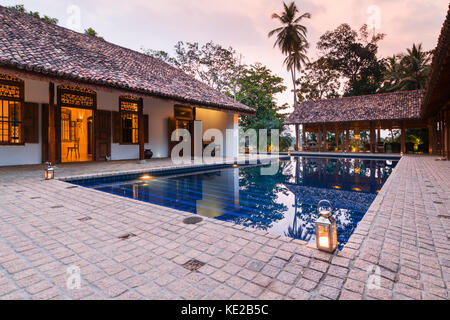 Swimmingpool und Boutique-Hotelterrasse in Tangalle, Sri Lanka, beleuchtet von Kerzenlaternen. Stockfoto