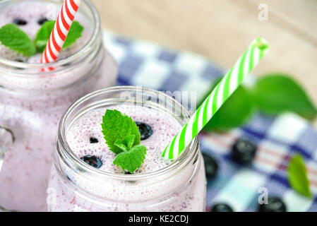 Blick von oben auf ein Blueberry Smoothie mit frischen Bio Blaubeeren, Minze und Joghurt im Vintage Glas auf einen hölzernen Tisch. Stockfoto