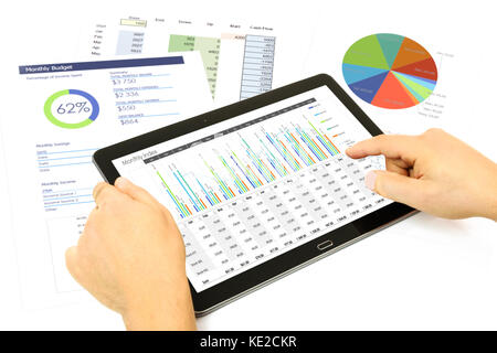 Das zusammengesetzte Bild im Geschäftsmann Analyse Investitionen Charts auf der digitalen Tablet-PC im Büro. Stockfoto