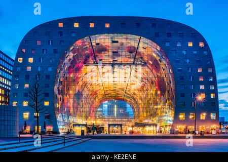 Markthalle im Blaak-Viertel von Rotterdam in der Abenddämmerung. Es ist ein Wohn- und Bürogebäude mit einer Markthalle darunter. Stockfoto
