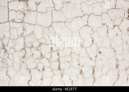 Schäbig und Schmutzig weiß gestrichene Betonwand Oberfläche in Risse Stockfoto