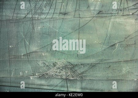 Beschädigte, zerbrochene Glasscheibe mit schwarzen Risse auf grünem Hintergrund Stockfoto