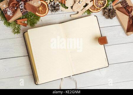 Weihnachtsschmuck und eine offene leer Notebook auf hellem Holztisch Stockfoto