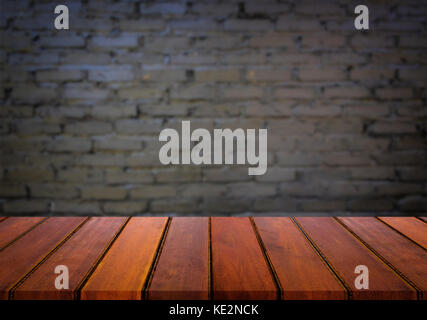 Ausgewählte Schwerpunkte leeren braunen Holz- Tisch und Wand Textur oder alten schwarzen Mauer blur Hintergrundbild. Für ihre Fotomontage oder Produkt anzeigen Stockfoto