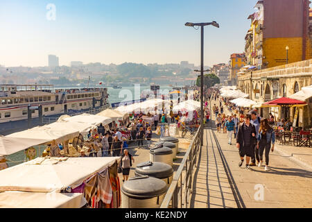 Massen von Touristen, die Bars und Cafes inribeiro Bezirk am Ufer des Douro in Porto, Portugal Stockfoto