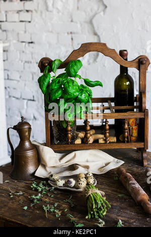 Die Flasche Wein, Basilikum und Zutaten zum Kochen in der Küche im Landhausstil Stockfoto