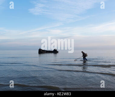 Ein Fischer Spaziergänge entlang der Küste vor einem schiffbruch an der Küste von Kent Stockfoto