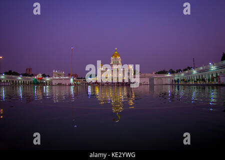 Delhi, Indien - 19. September 2017: schöner Ausblick auf den berühmten goldenen Tempel der Sikhs gurdwara harmandir Sahib in der künstlichen Teich wider, mit einem wunderschönen violetten Himmel in Indien Stockfoto