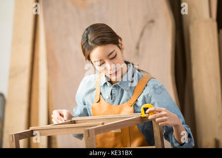 Porträt der jungen weiblichen woodworker konzentriert sich auf ihre Arbeit Stockfoto