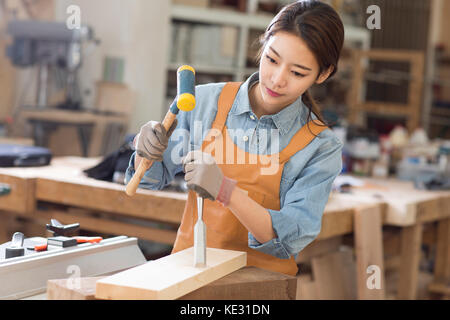 Porträt der jungen weiblichen woodworker konzentriert sich auf ihre Arbeit Stockfoto